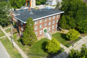 An exterior photograph of a three-story brick apartment building.