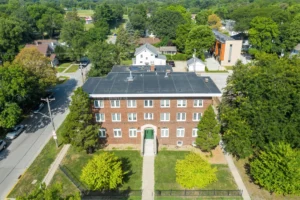 An exterior photograph of a three-story brick apartment building.