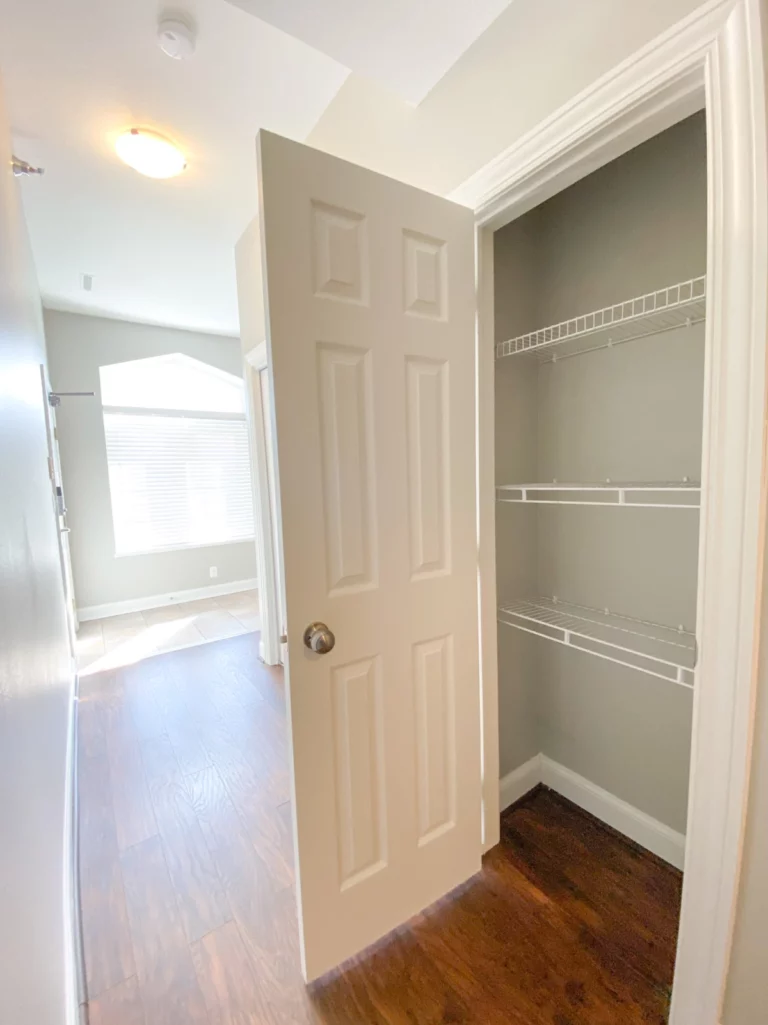 Photograph of hallway and hallway closet with wire shelves.
